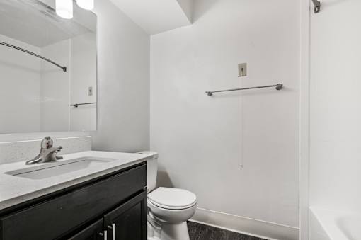 A bathroom with a toilet, sink, and shower.